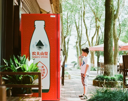 一个年轻男孩走在靠近一家餐厅的人行道上。