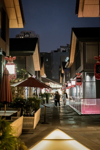 夜晚的城市街道 人们沿着街道走 建筑物被照亮。