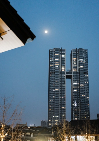 城市中 高楼后面升起满月