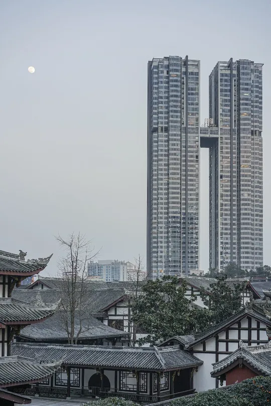 城市中的高楼大厦上 一轮满月升起。