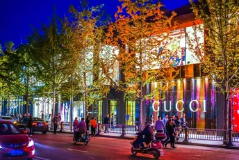 夜晚的城市街道 汽车、摩托车和人们在建筑物前。