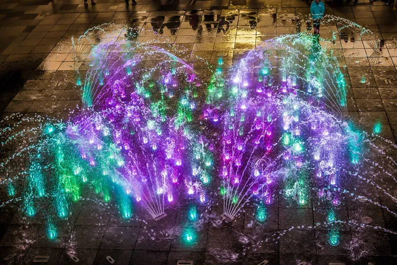 广场中央有一座喷泉被灯光照亮了。