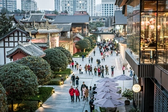 许多人带着伞在城市的步行道上行走