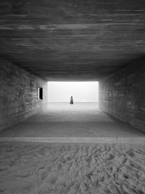 在海滩尽头的一个隧道口站着一个人