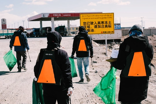 几个人在加油站附近的一条路上走。