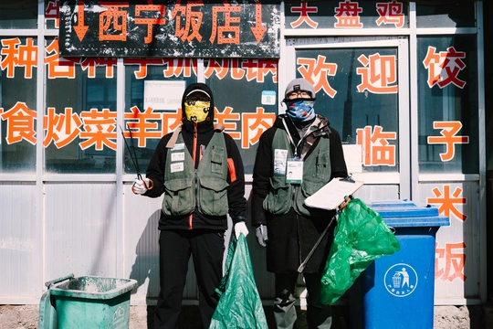 几个戴面具的男人站在一栋楼前