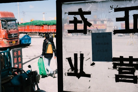 一个人走过一个显示公交车的标志牌的街道