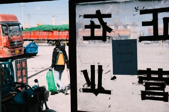 一个人走过一个显示公交车的标志牌的街道