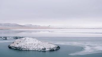 雪覆盖的冰冻湖 背景是山峦