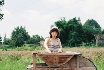 站在田野里木桌或木车旁的年轻女子