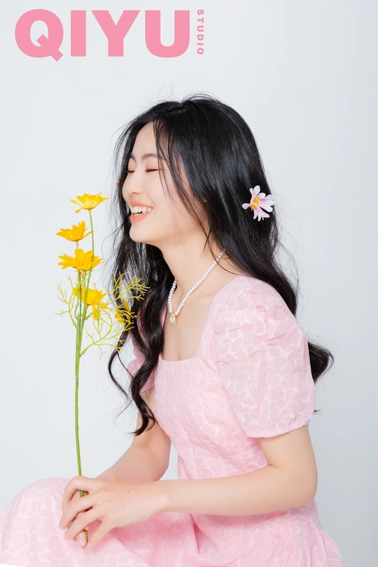 一位穿着粉红色连衣裙 头戴黄色花朵的年轻女子