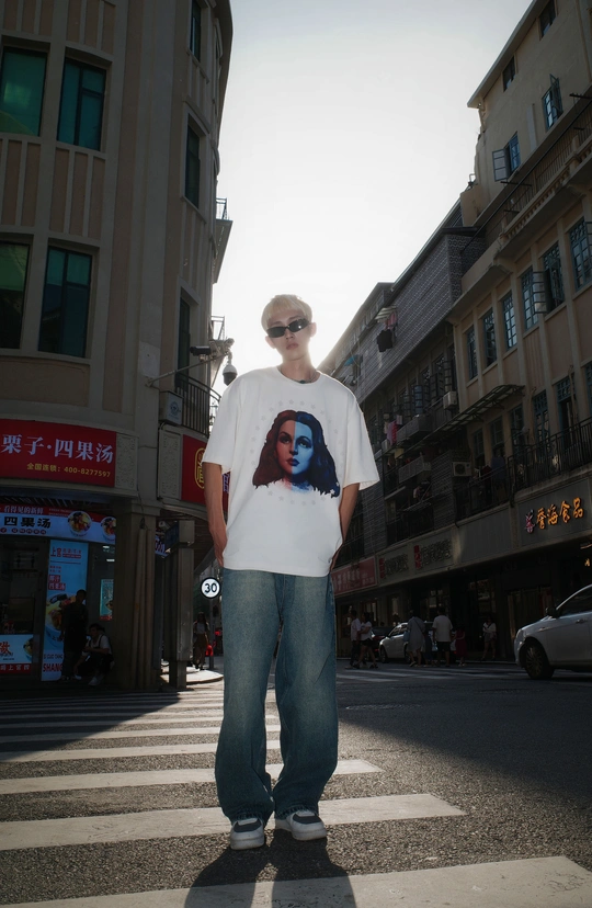 一个穿着白色T恤的年轻人站在滑板上