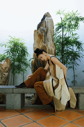 一个穿着连衣裙的年轻女子坐在长凳上