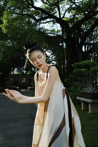 一位穿着连衣裙的年轻女子站在公园里