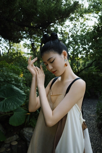 一位年轻女子穿着裙子站在外面