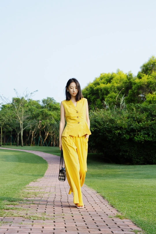 一位穿着黄色连衣裙和黄色裤子的女士