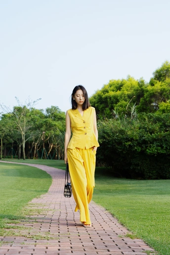 一位穿着黄色连衣裙和黄色裤子的女士