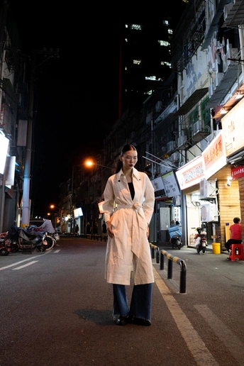 一个穿着白大褂的女人在晚上沿着街道走 同时还在通话中