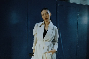 一位穿着长雨衣和白色连衣裙的模特