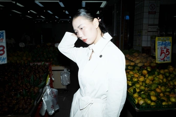 一个穿着白色长袍的年轻女子站在市场里