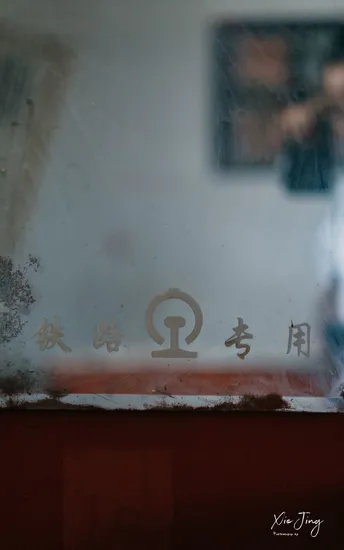 一个通过脏窗户拍摄 玻璃上有中国符号反射的男人