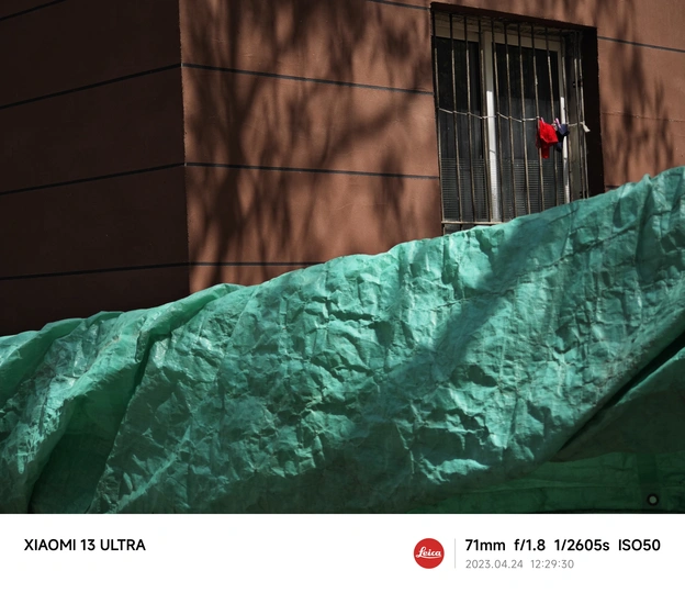 一栋带有红色窗户和绿色布料覆盖墙壁的建筑