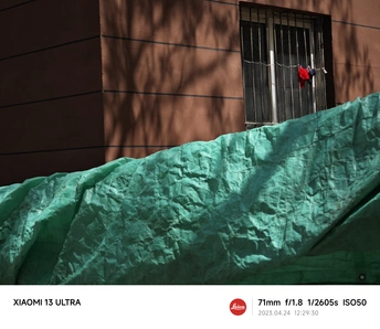 一栋带有红色窗户和绿色布料覆盖墙壁的建筑