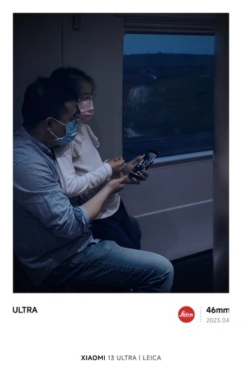 一个戴面具的男子坐在戴口罩的女子旁边 火车上看着手机。