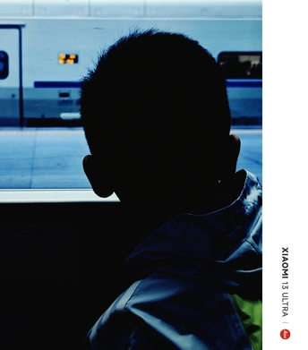 一个人坐在火车或地铁上 正在窗口看着一个男孩