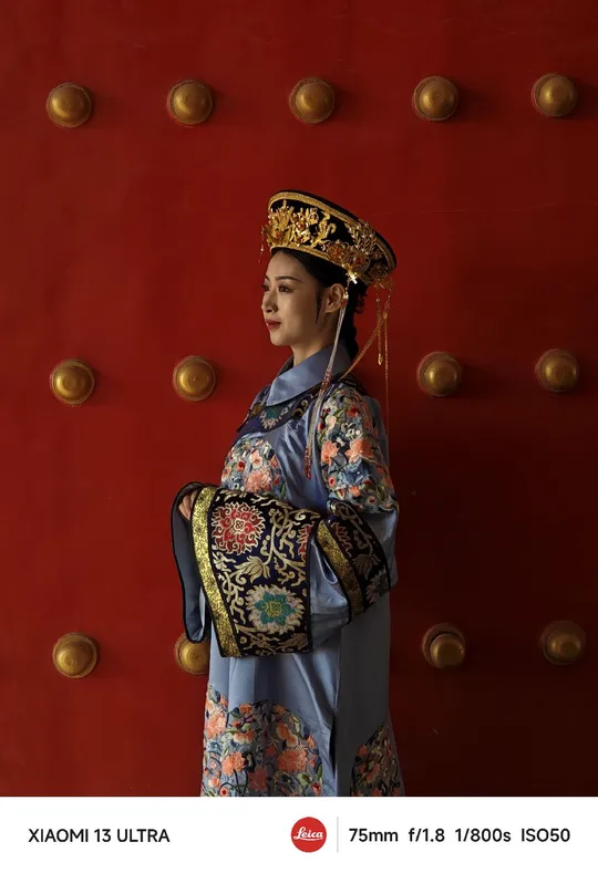 一位穿着传统服装的女性站在门前