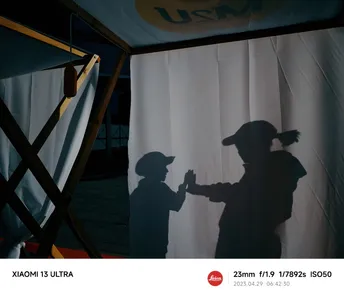 站在舞台前面的戴帽子的男人的影子