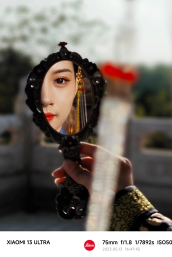 女人举着镜子照着她的脸