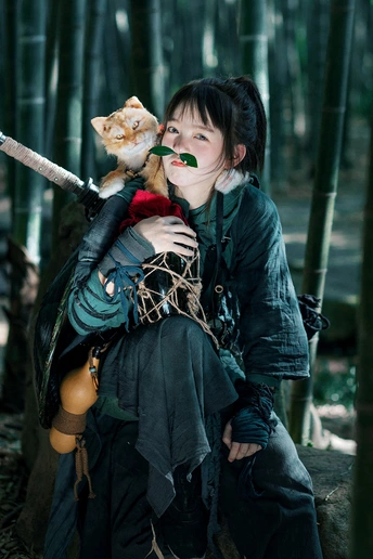 一个穿着服装的女人在森林中抱着一只猫