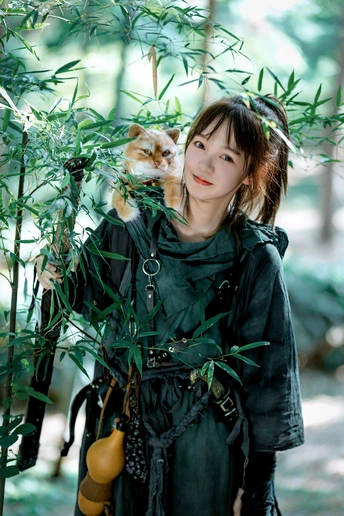 一位穿着连衣裙的年轻女子抱着一只猫站在一盆植物旁边