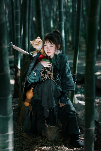 一位年轻女子在竹林中抱着一只猫