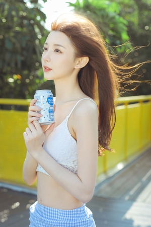 一位年轻美丽的女子手里拿着一罐水