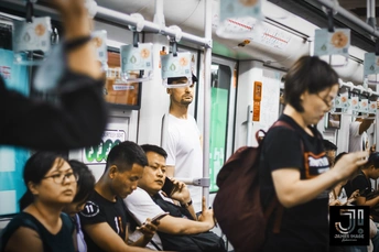 人们在地铁列车上看着手机