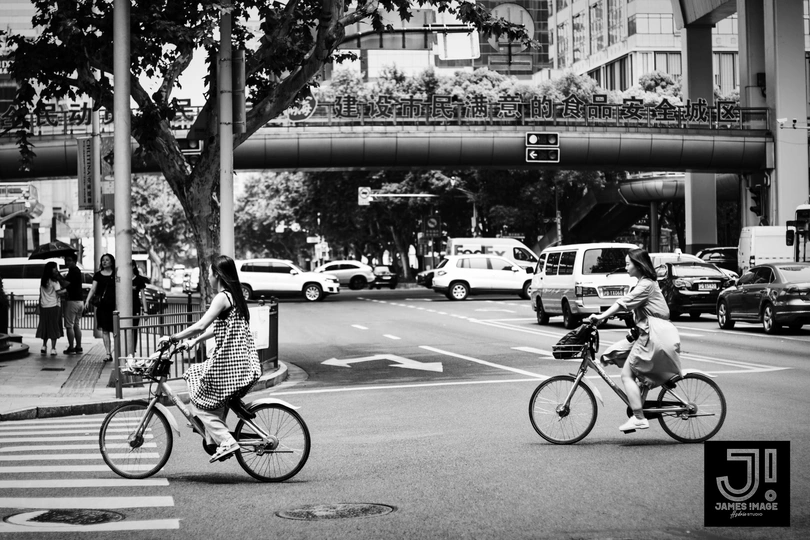 黑白相间的交叉口 人们骑自行车和汽车在街道上。