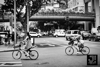 黑白相间的交叉口 人们骑自行车和汽车在街道上。