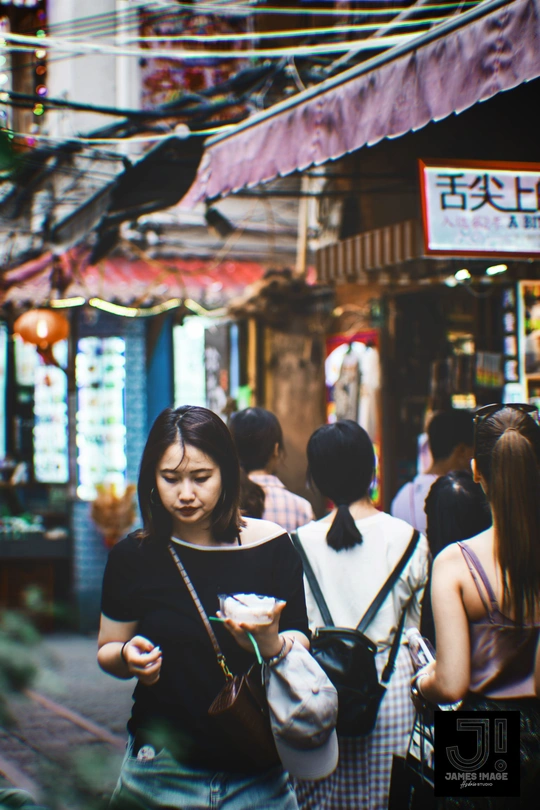 一批年轻人走在亚洲市场拥挤的街道上