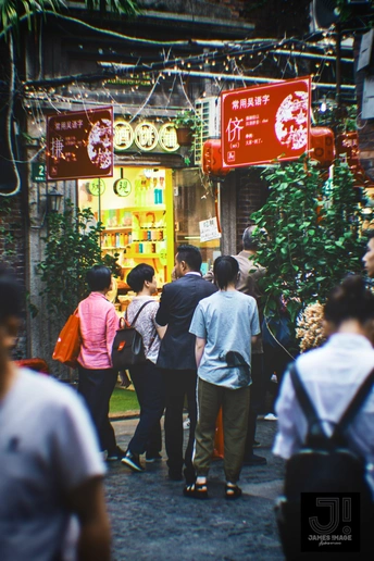 人群沿着街道上的许多商店和标志走下