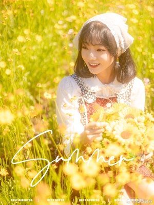 一个小女孩穿着白色衣服 手里拿着一朵黄色的花在田野里。