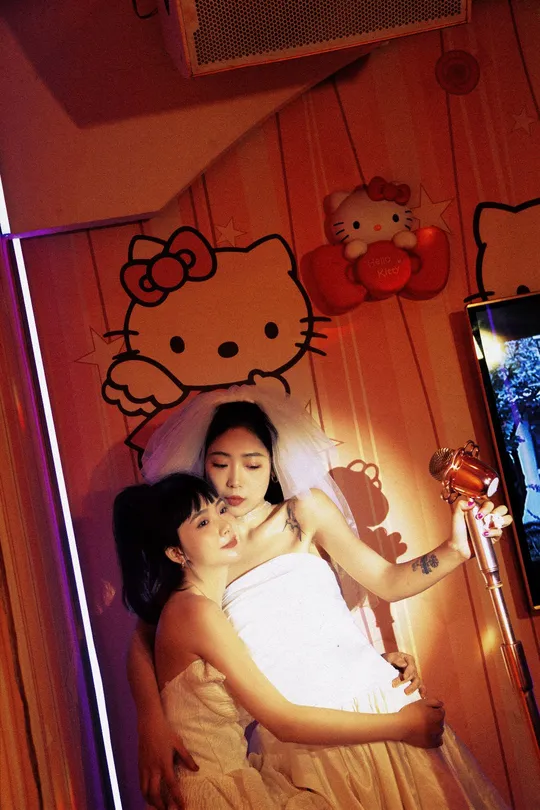 一位年轻女子抱着一个年轻女孩在电视前拍照