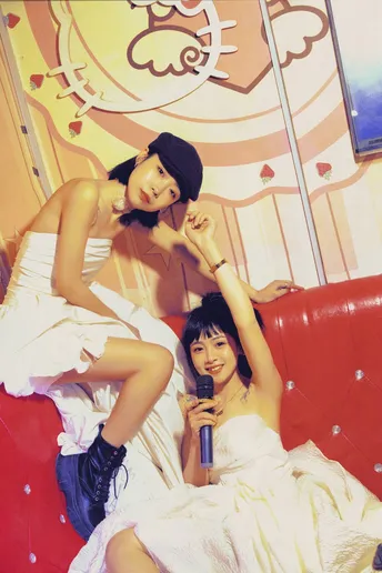 一个穿着白色连衣裙的女人坐在红色的沙发上