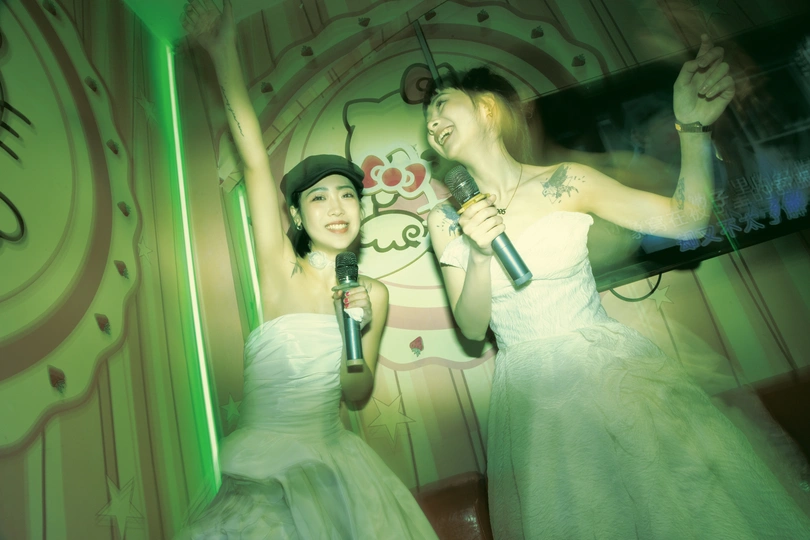 站在一位穿着连衣裙的女士旁边的男人拿着话筒