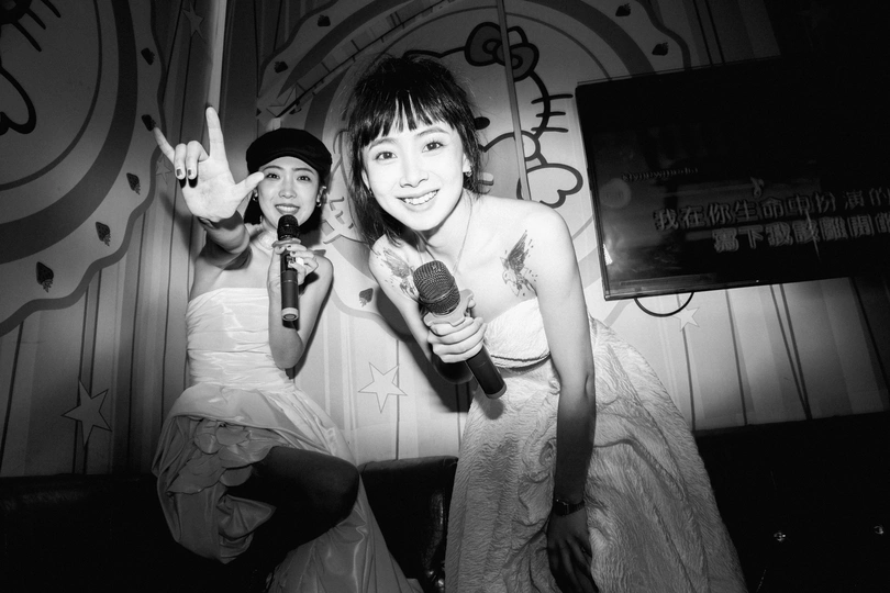 一位年轻男子手持麦克风站在一位女子旁边唱歌