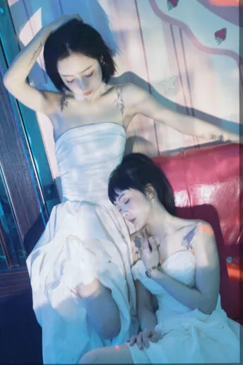 一个穿白裙子的年轻女子坐在红色的沙发上