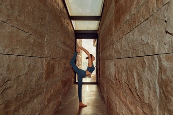 在古代墙壁上练习瑜伽的女人