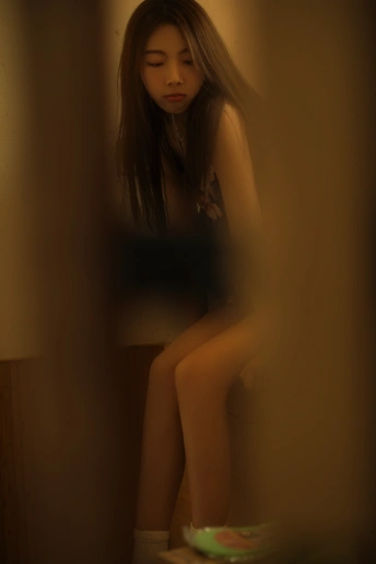 一位年轻女子坐在镜子前的一级台阶上