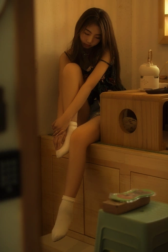 一个年轻女子坐在一个凳子上
